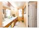 Well-lit bathroom featuring a long double vanity, framed mirror and natural lighting at 24191 E Iowa Pl, Aurora, CO 80018