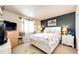 Bedroom featuring decorative pillows, floral bedding, dark accent wall, and bright window at 24191 E Iowa Pl, Aurora, CO 80018