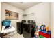 Modern laundry room with black washer and dryer, shelving and overhead lighting at 24191 E Iowa Pl, Aurora, CO 80018