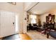 Cozy living room featuring hardwood floors, a leather sofa, and natural light from the front door at 24191 E Iowa Pl, Aurora, CO 80018