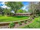 Lush green backyard with mature trees, a charming patio, and beautifully maintained landscaping at 7800 Indiana St, Arvada, CO 80007
