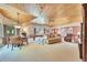 Expansive basement with wood ceiling, billiards table, and comfortable seating area at 7800 Indiana St, Arvada, CO 80007