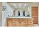 Bathroom vanity featuring stone countertops, wood cabinets, and plenty of natural light at 7800 Indiana St, Arvada, CO 80007