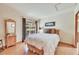 Bedroom featuring white bedding, a sliding glass door, and an adjacent mirrored dresser at 7800 Indiana St, Arvada, CO 80007