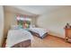 Comfortable bedroom with two twin beds, white comforters, and a charming window view at 7800 Indiana St, Arvada, CO 80007