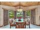 Bright dining area with many windows, wood trim, and glass table with seating for four at 7800 Indiana St, Arvada, CO 80007