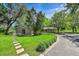 Brick home featuring beautiful landscaping and a detached brick accessory building at 7800 Indiana St, Arvada, CO 80007