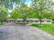 Expansive front yard with mature trees and a long driveway leading to a beautiful brick home at 7800 Indiana St, Arvada, CO 80007
