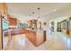 Open kitchen layout with an island, wine storage, stainless appliances, and natural light at 7800 Indiana St, Arvada, CO 80007
