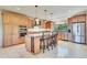 Bright kitchen with a large island with seating, modern appliances, and travertine tile flooring at 7800 Indiana St, Arvada, CO 80007
