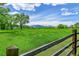 Expansive green field with mountain views and a rustic wooden fence at 7800 Indiana St, Arvada, CO 80007