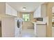Bright laundry room featuring ample cabinet space, a countertop, and modern washer and dryer appliances at 7800 Indiana St, Arvada, CO 80007