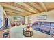 Bright living room with a plush sofa, beamed ceiling, and view of the front yard at 7800 Indiana St, Arvada, CO 80007