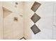Close-up of a tiled shower featuring a decorative tile accent and modern fixtures at 7800 Indiana St, Arvada, CO 80007