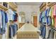 Spacious walk-in closet with custom shelving and center island with access to bathroom at 7800 Indiana St, Arvada, CO 80007