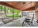 Covered back porch with patio furniture overlooking a landscaped backyard at 6991 Warren Dr, Denver, CO 80221