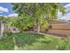 Landscaped backyard featuring a mature tree, patio, and a well-maintained lawn at 6991 Warren Dr, Denver, CO 80221