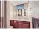 Bathroom with a stylish vanity, decorative wallpaper, and custom vanity mirror with decorative light fixtures at 6991 Warren Dr, Denver, CO 80221