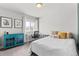 Bright bedroom with a desk, a turquoise cabinet, and framed art enhances the room's aesthetics at 4774 Kittredge St, Denver, CO 80239