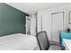 Bedroom featuring a white bed, modern desk, and a painted accent wall at 4774 Kittredge St, Denver, CO 80239