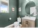Stylish powder room features a floating vanity with a vessel sink, a round mirror, and a window at 4774 Kittredge St, Denver, CO 80239