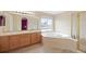 Bright bathroom features a soaking tub with tile surround, double sink vanity, and glass shower at 13078 Monaco Way, Thornton, CO 80602