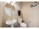 Cozy half bathroom showcasing an oval mirror, pedestal sink, and floral art on the wall at 13078 Monaco Way, Thornton, CO 80602