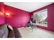 Bright bedroom with red walls, neutral carpet, and a large window with a neighborhood view at 13078 Monaco Way, Thornton, CO 80602