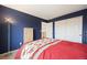 Bedroom featuring navy walls, neutral carpet, and a closet at 13078 Monaco Way, Thornton, CO 80602