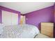 Bright bedroom featuring purple walls, neutral carpet, and white closet doors at 13078 Monaco Way, Thornton, CO 80602