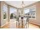 Sunlit breakfast nook features a glass table, wood floors, and sliding doors to the backyard at 13078 Monaco Way, Thornton, CO 80602