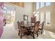 Elegant dining room with a grand table, chandelier, and tall windows for a bright, inviting atmosphere at 13078 Monaco Way, Thornton, CO 80602