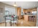 Eat-in kitchen features stainless steel appliances, a breakfast bar, wood cabinets, and a hardwood floor at 13078 Monaco Way, Thornton, CO 80602