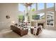 Cozy living room with high ceilings, large windows, a fireplace, and comfortable leather seating at 13078 Monaco Way, Thornton, CO 80602