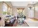 Inviting living room with large windows, neutral walls, and stylish leather furniture at 13078 Monaco Way, Thornton, CO 80602