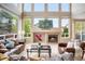 Inviting living room with large windows, a cozy fireplace, and comfortable leather furniture at 13078 Monaco Way, Thornton, CO 80602