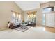 Comfortable living room featuring large windows, neutral walls, and stylish leather furniture at 13078 Monaco Way, Thornton, CO 80602