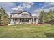 Spacious backyard with patio seating, hot tub, well maintained lawn, and mature trees at 4586 Carefree Trl, Parker, CO 80134