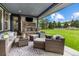 Relaxing covered patio with fireplace and furniture overlooking a beautiful lawn at 4586 Carefree Trl, Parker, CO 80134