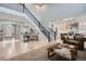 Bright and airy living room featuring a staircase and a view into the modern kitchen at 4586 Carefree Trl, Parker, CO 80134