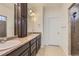Bathroom with double vanity, dark wood cabinets, quartz countertops, and tiled shower at 19753 E 54Th Ave, Denver, CO 80249