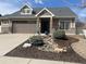 Inviting home exterior with stone accents, low-maintenance landscaping, and a spacious driveway at 19753 E 54Th Ave, Denver, CO 80249