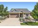 Charming home featuring a well-manicured lawn, stone accents, and a two-car garage with a large driveway at 19753 E 54Th Ave, Denver, CO 80249