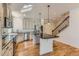 Well-lit kitchen featuring stainless steel appliances, a center island, and easy access to the staircase at 19753 E 54Th Ave, Denver, CO 80249