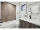 Bathroom featuring a bathtub, shower with subway tile, wood-paneled accent wall, and modern fixtures at 2162 S Ash St, Denver, CO 80222