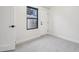 Minimalist bedroom with light-colored carpet, a window, a door, and white walls at 2162 S Ash St, Denver, CO 80222