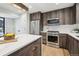 Modern kitchen with stainless steel appliances, wood cabinets, quartz countertop island, and hardwood floors at 2162 S Ash St, Denver, CO 80222