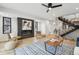 Open-concept living room featuring a modern fireplace, hardwood floors, and staircase at 2162 S Ash St, Denver, CO 80222