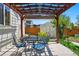 Charming backyard patio area with pergola, outdoor seating, and a well-maintained shed at 16278 E 105Th Way, Commerce City, CO 80022
