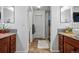 A neutral toned bathroom featuring double sinks, granite countertops, and a glass enclosed shower at 16278 E 105Th Way, Commerce City, CO 80022